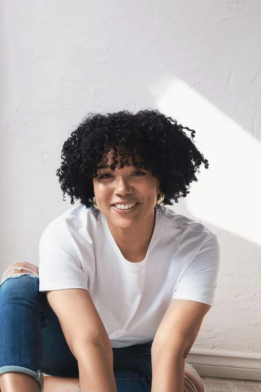 4C hair routine: smiling woman with tight, well-moisturized coils
