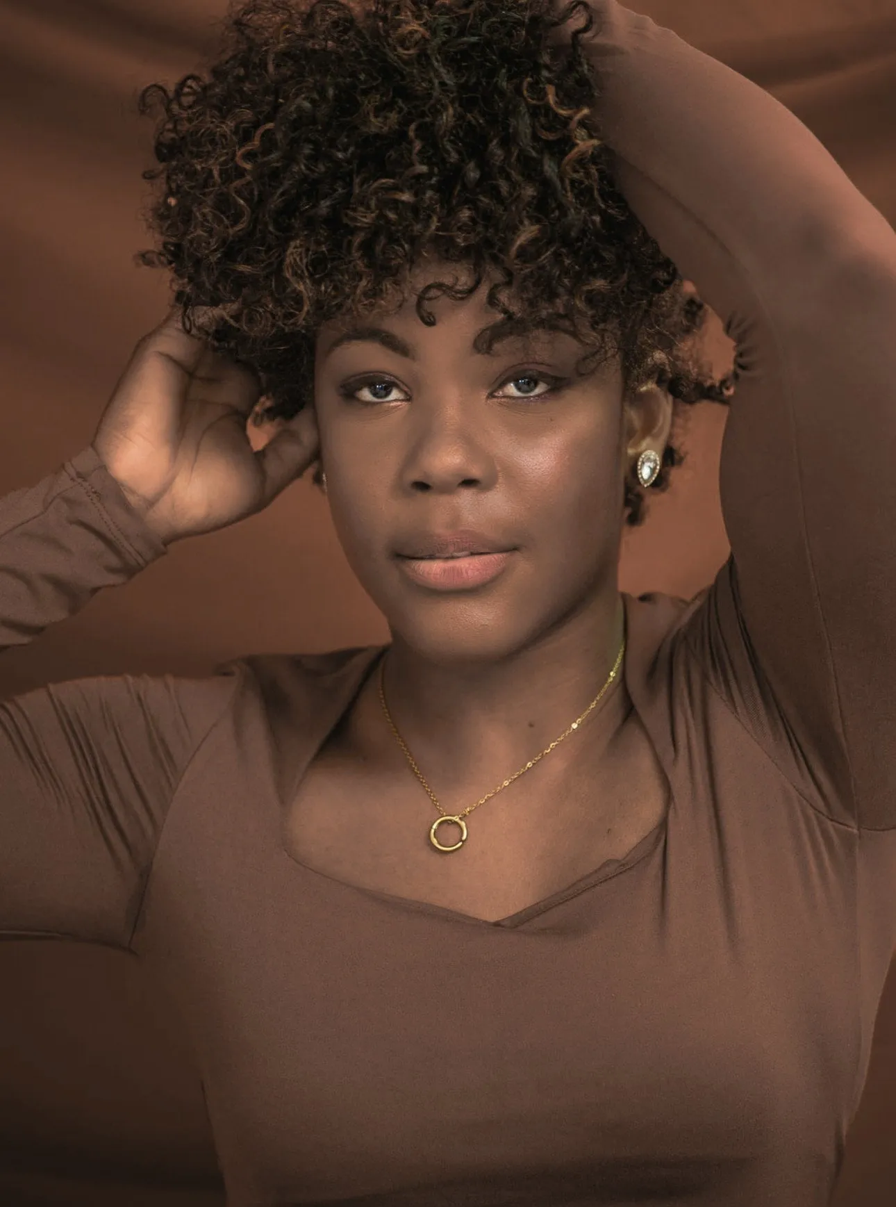 Soins pour cheveux afro : femme aux boucles crépues hydratées, mains dans les cheveux