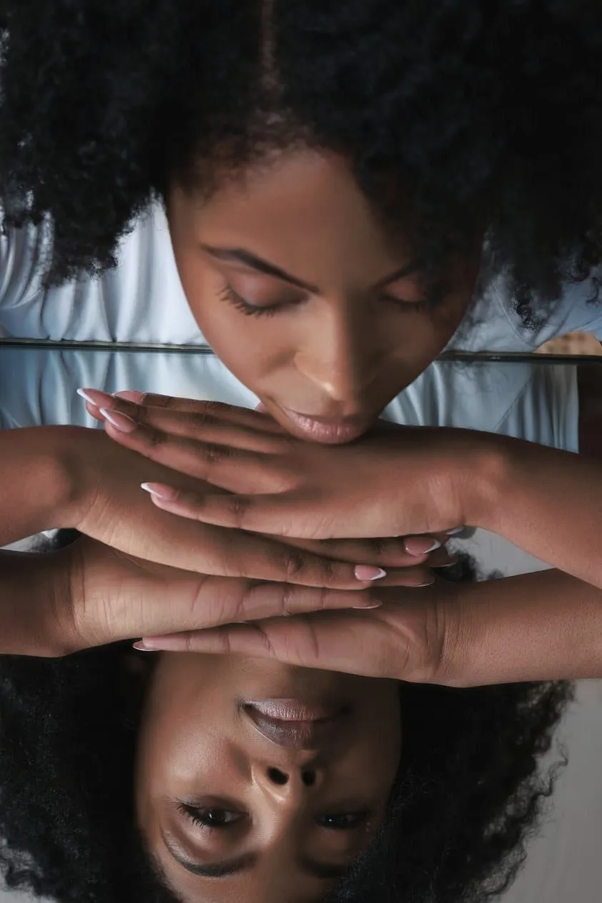Femme aux cheveux crépus naturels qui se regarde dans le miroir, aimer ses boucles