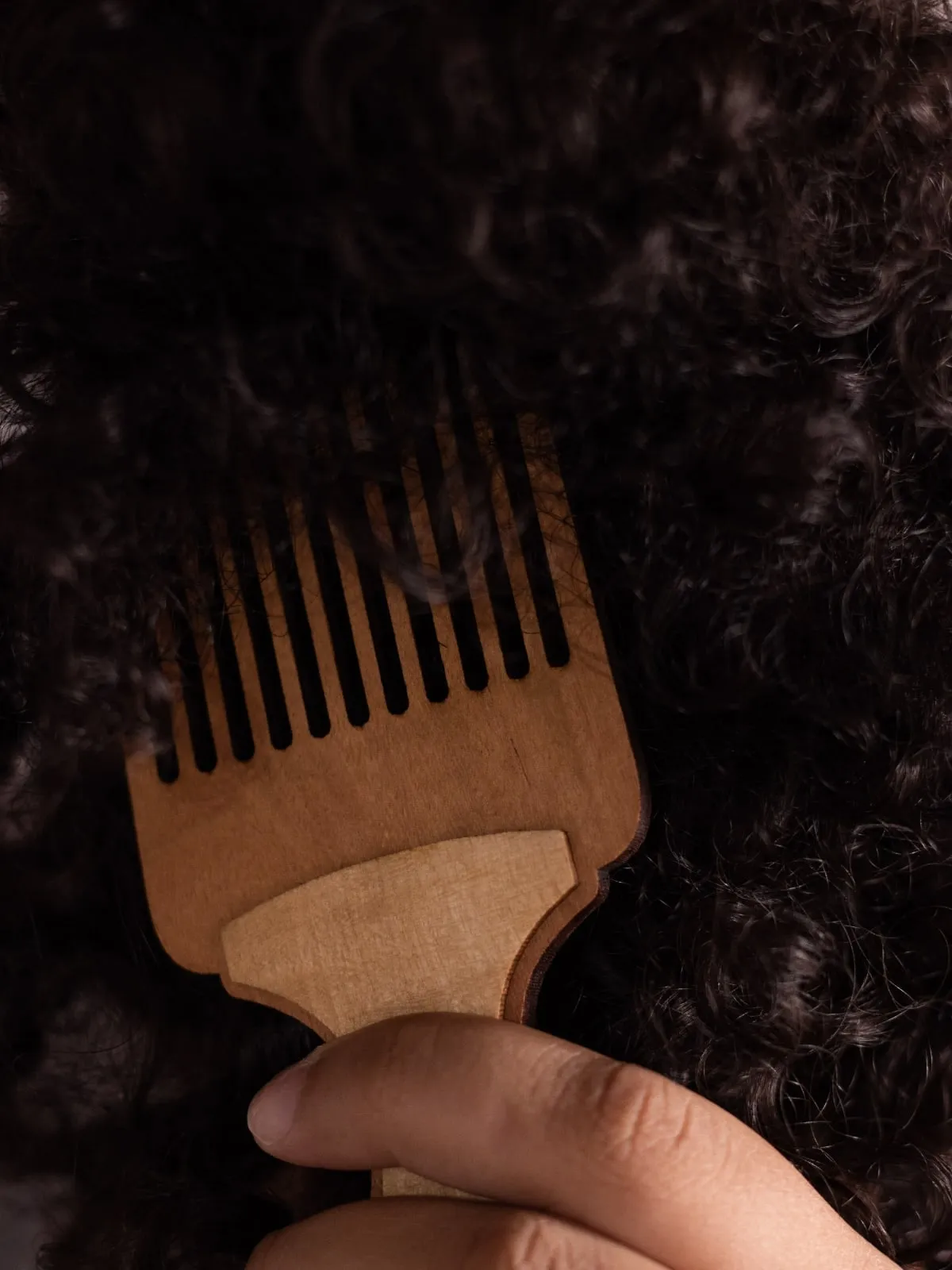 Getting ready for a silk press: wooden afro comb in coily hair